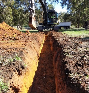 A trench digger machine digging a trench.